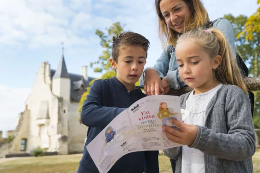 Jeunes enfants et leur mère à Chinon lisant des instructions sur un dépliant