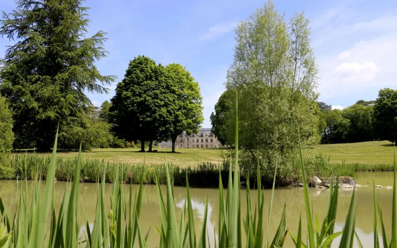 Vue sur le plan d'eau au premier plan et le chateau au fond