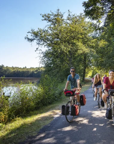 Cyclistes sur la route au bord de l'étang